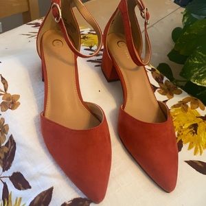 Burnt orange suede with pointed toes, ankle straps and chunky 1 3/4 inch heel.